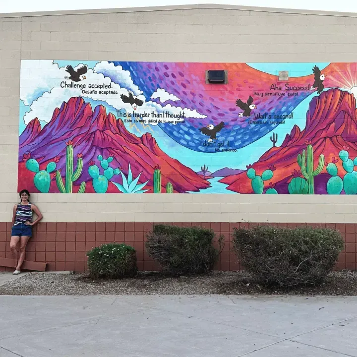 Bilingual eagles growth-mindset mural on the Desert Thunder school wall, Brigitte De Marco at left