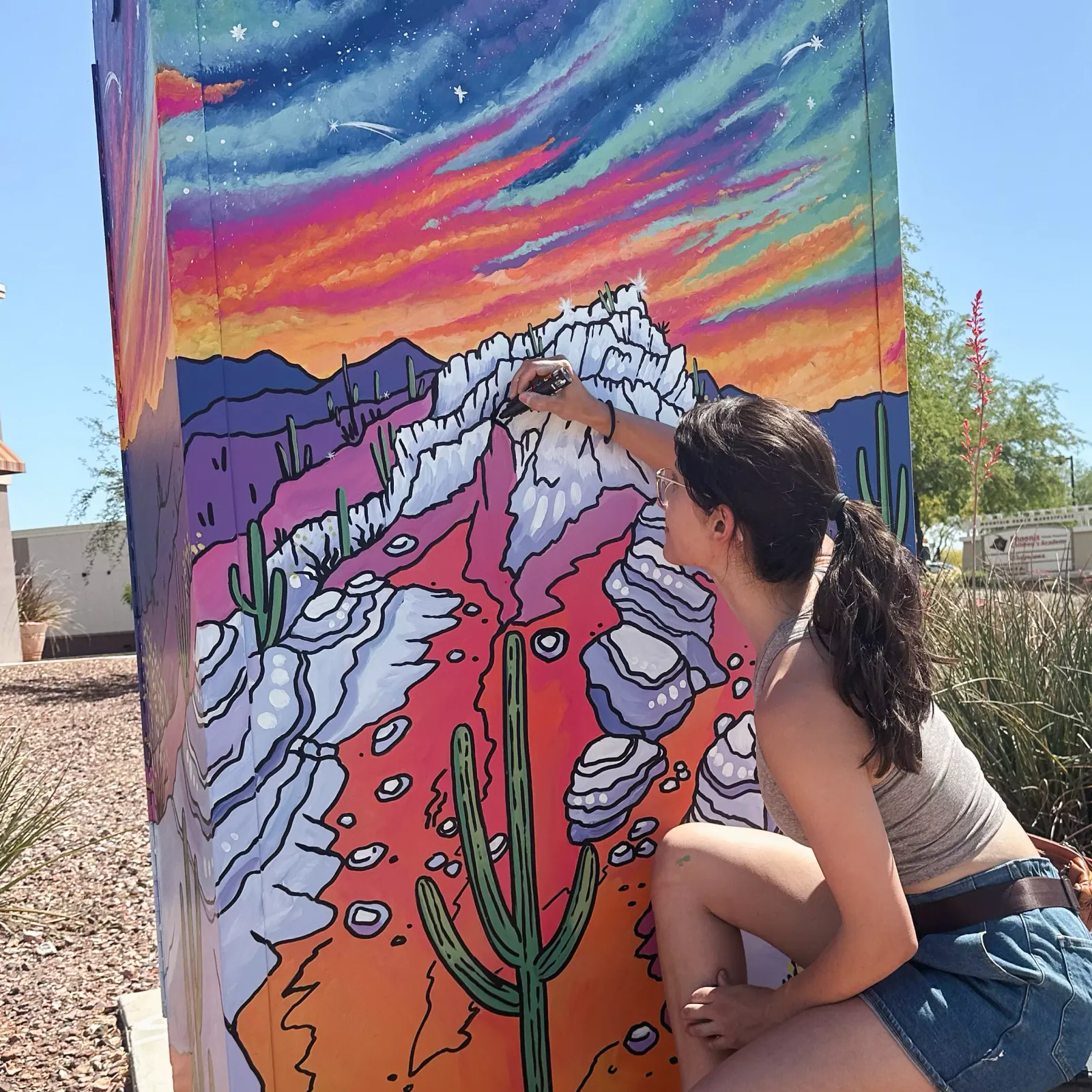 Brigitte De Marco signing her painted traffic-signal cabinet in Goodyear