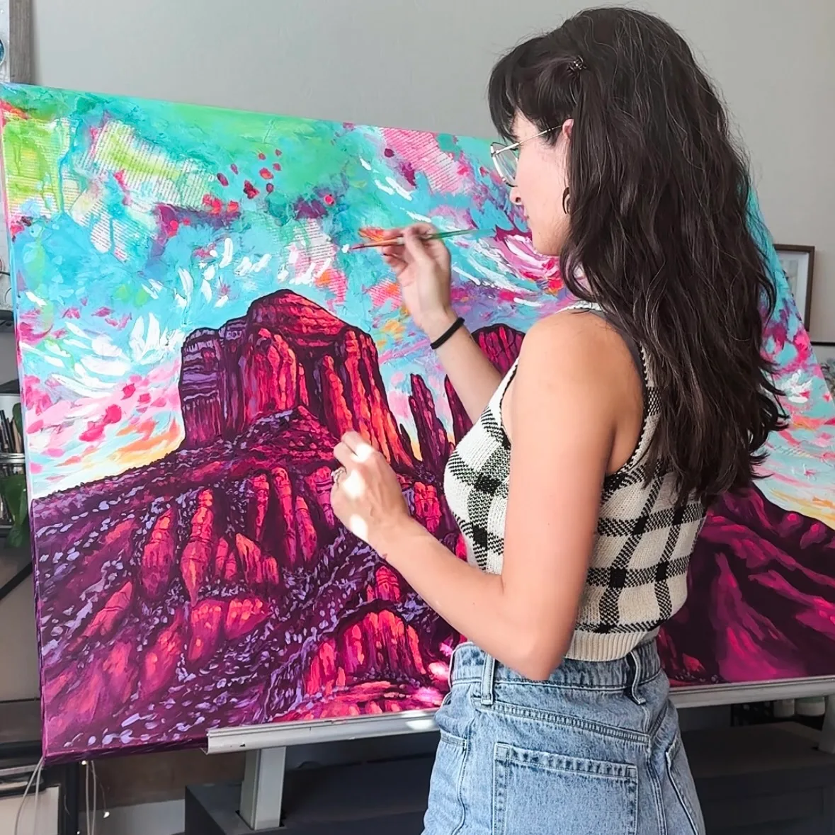 Brigitte De Marco painting a red rock landscape at her easel