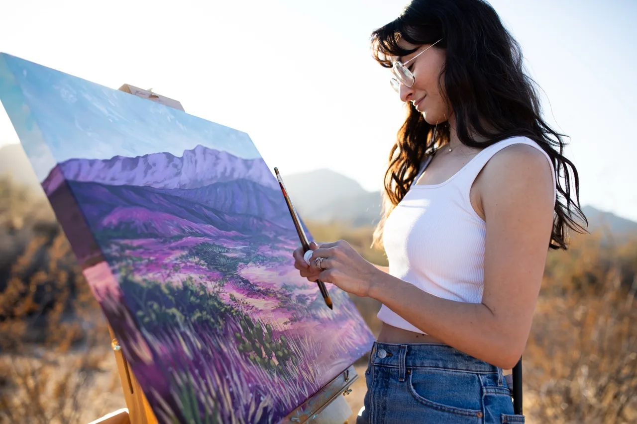 Brigitte De Marco painting a purple desert landscape outdoors